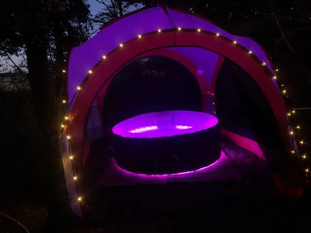 Bulle des 2 Arbres de la Sagesse : spa privatif éclairé la nuit sous sa tonnelle