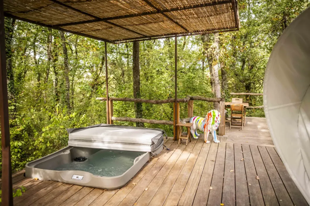 Cœur de Bull' : terrasse couverte avec spa au milieu des arbres