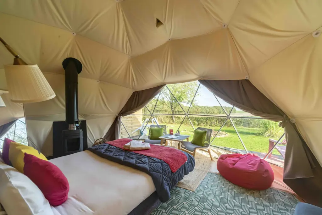Le Nid du Tui : intérieur du Zen Dome avec poêle à bois