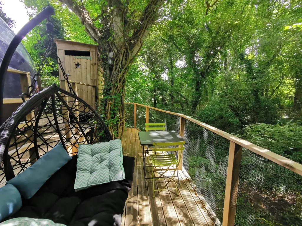 Les Roulottes du Trieux : terrasse sur pilotis avec fauteuil suspendu